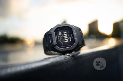 CASIO GBD-200-1DR G-Squad GBD-200 系列手錶 - 手錶置於戶外日出場景，金屬欄杆時尚生活照