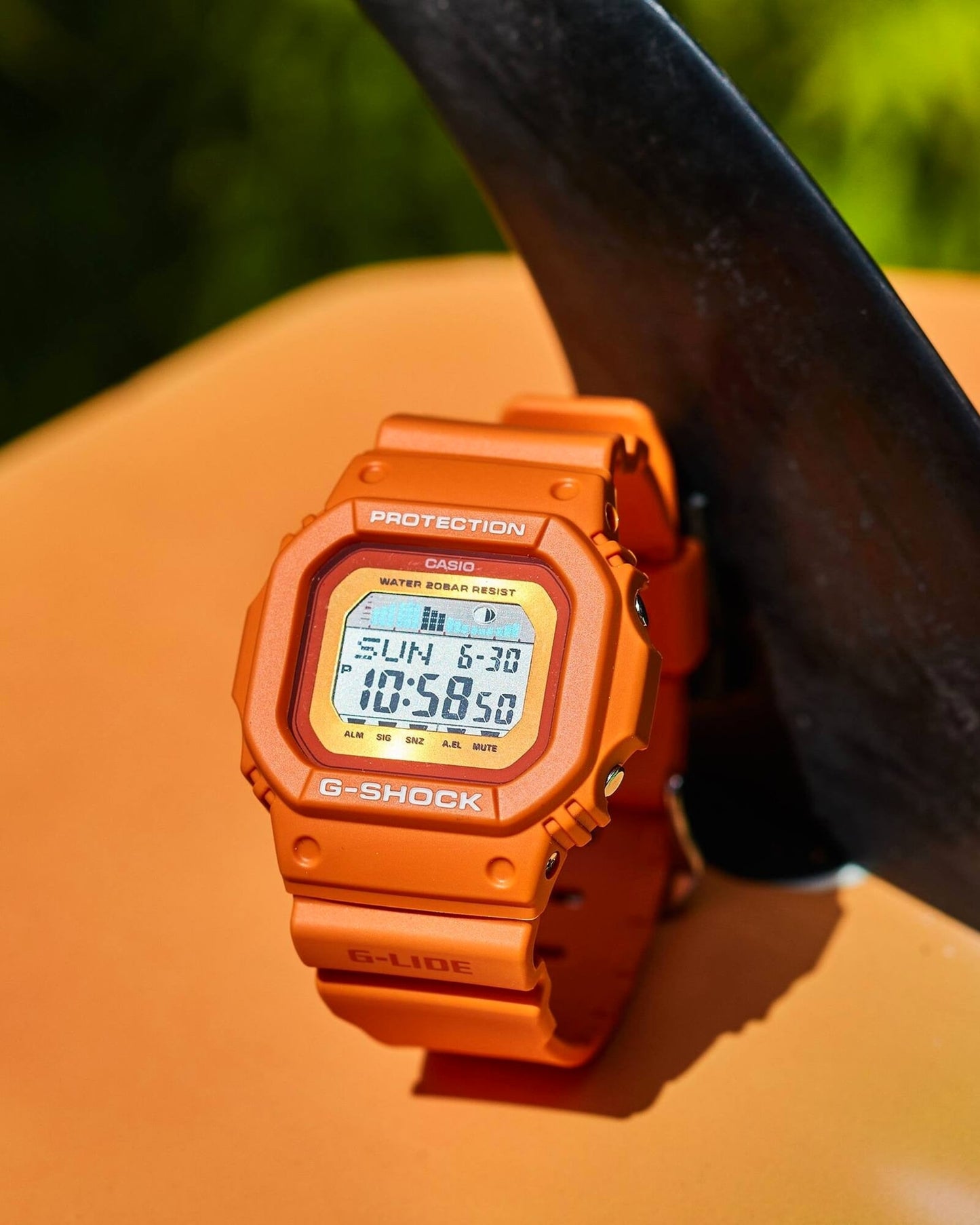 CASIO GLX-5600RT-4ER G-Shock G-Lide 手錶 - 手錶擺放於橙色滑浪板上，戶外特寫照