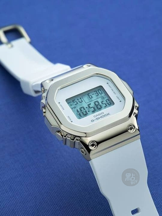 CASIO GM-S5600G-7ER GM-S5600 Series 數碼白色手錶 - 藍色背景斜角圖，展示金色錶圈